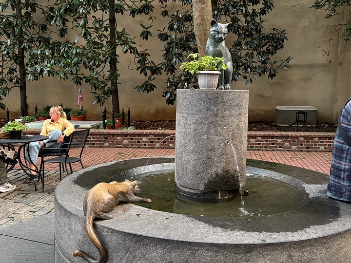 sculpture of cats playing in a fountain