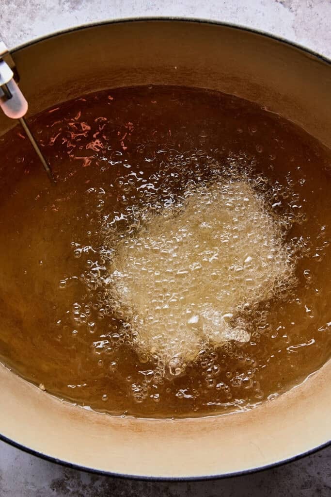 Dutch oven and thermometer setup for perfectly frying chicken thighs for the best fried chicken sandwich recipe.
Dutch oven and thermometer setup for perfectly frying chicken thighs for the best fried chicken sandwich recipe.
