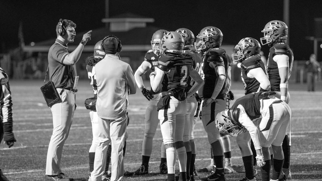 A group of football players standing on top of a field
