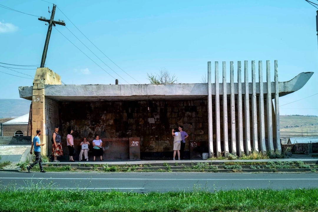 A group of people standing outside of a building A group of people standing outside of a building