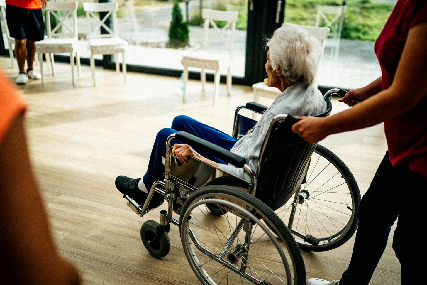 Senior Sitting in a Wheelchair in a Nursing Home · Free Stock Photo