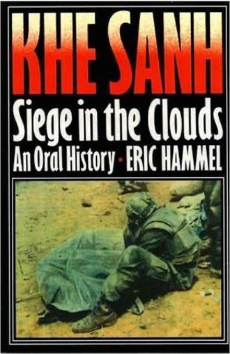Cover of Khe Sanh: Siege in the Clouds – An Oral History by Eric Hammel. The design features bold red and white text over a dark background, with a wartime photograph of a soldier crouched beside a fallen comrade on the battlefield.