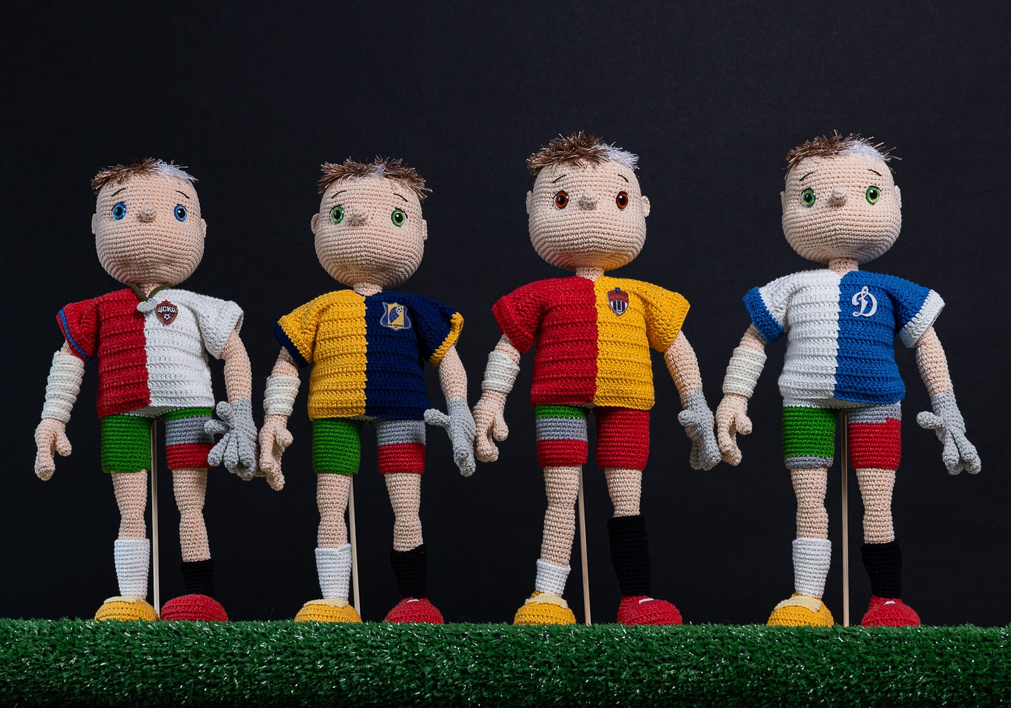 A series of crocheted football players, in various uniforms representing personalized statistics.