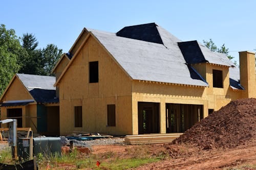 Free A partially built wooden house under construction, showcasing its progress and design in daylight. Stock Photo