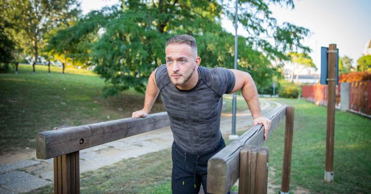 man in the parking performing bodyweight dips