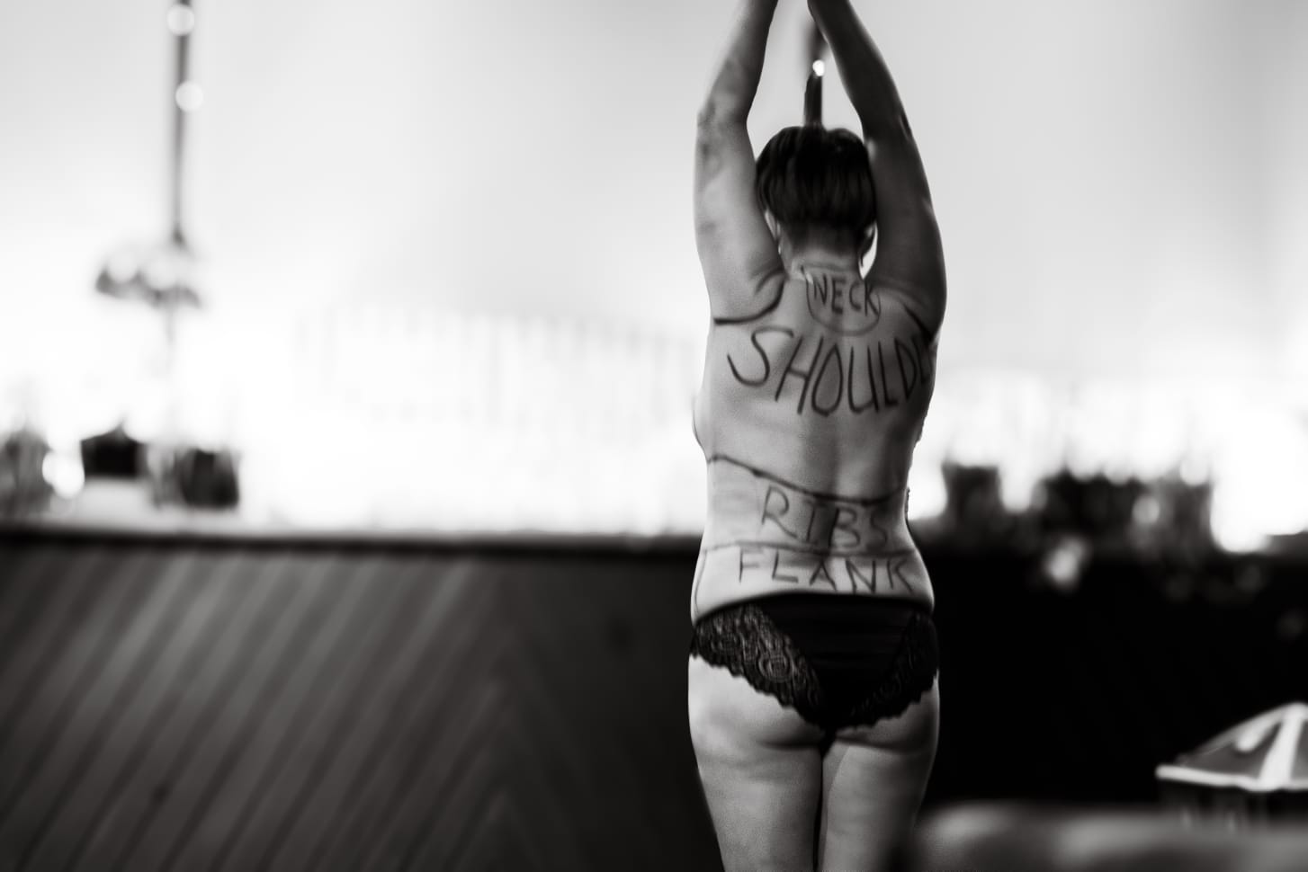 Scarlet Vikki wearing little and is covered in the names of body parts daubed on her back