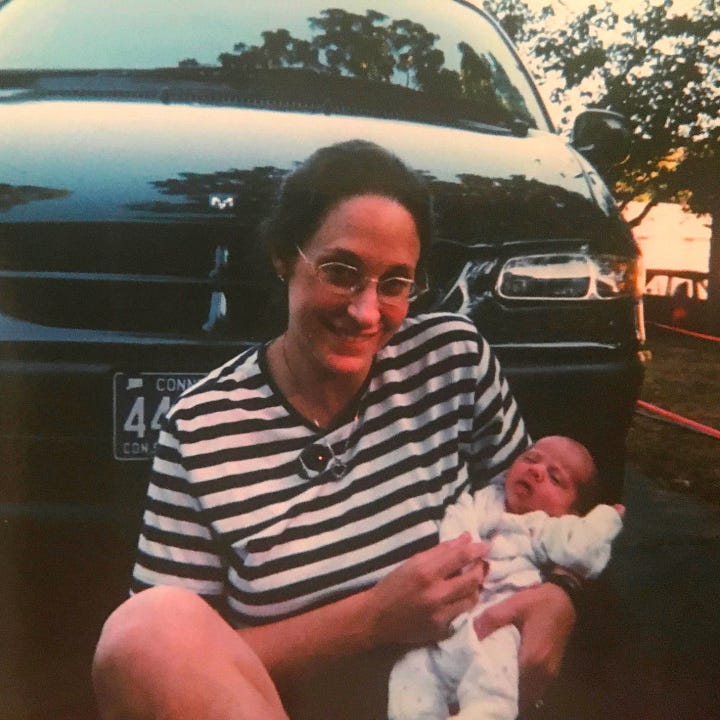 Image 1: A young boy smiles at his baby sister, a toy stethoscope on his ears as he pretends to listen to her heartbeat. Image 2: A new mom sits holding her weeks-old baby in front of a dark minivan.