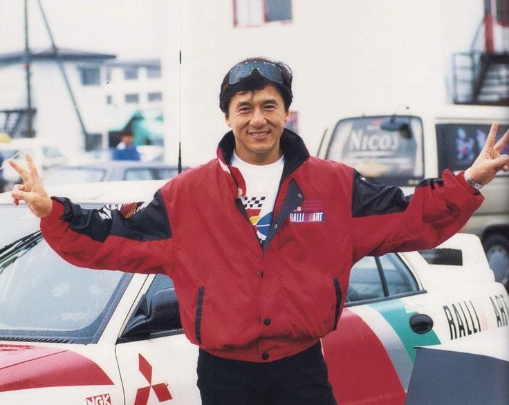 This may contain: a man standing in front of a car with his arms out and hands up to the side