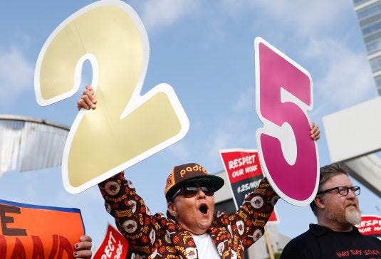 San Diego, CA - May 01: Monica Marin, of Chula Vista, holds up cardboard numbers during a protest for hospitality workers to make a minimum wage of $25/Hour at San Diego Bayfront Park on Wednesday, May 1, 2024 in San Diego, CA. (Meg McLaughlin / The San Diego Union-Tribune)