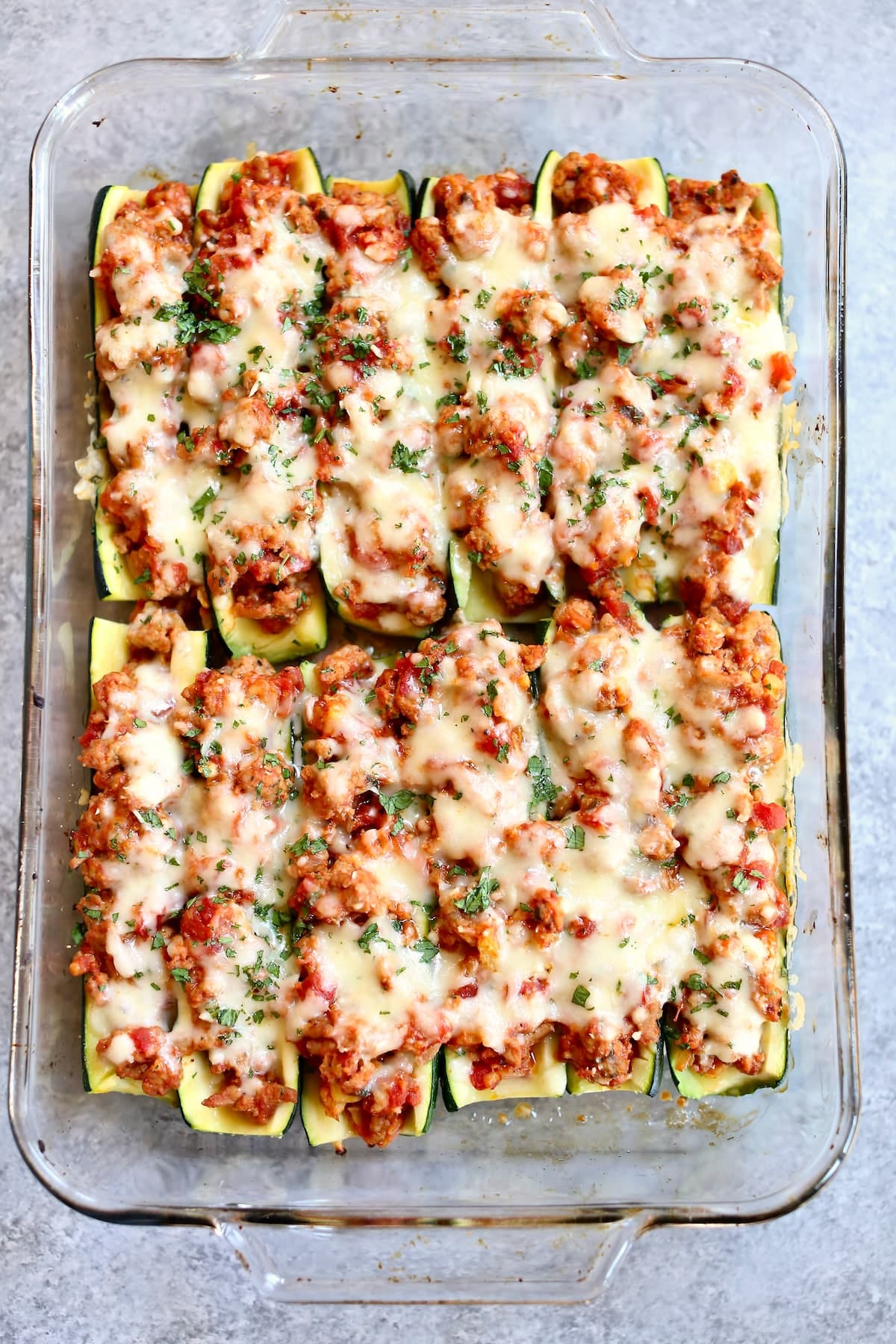 a baking dish of cooked stuffed zucchini.