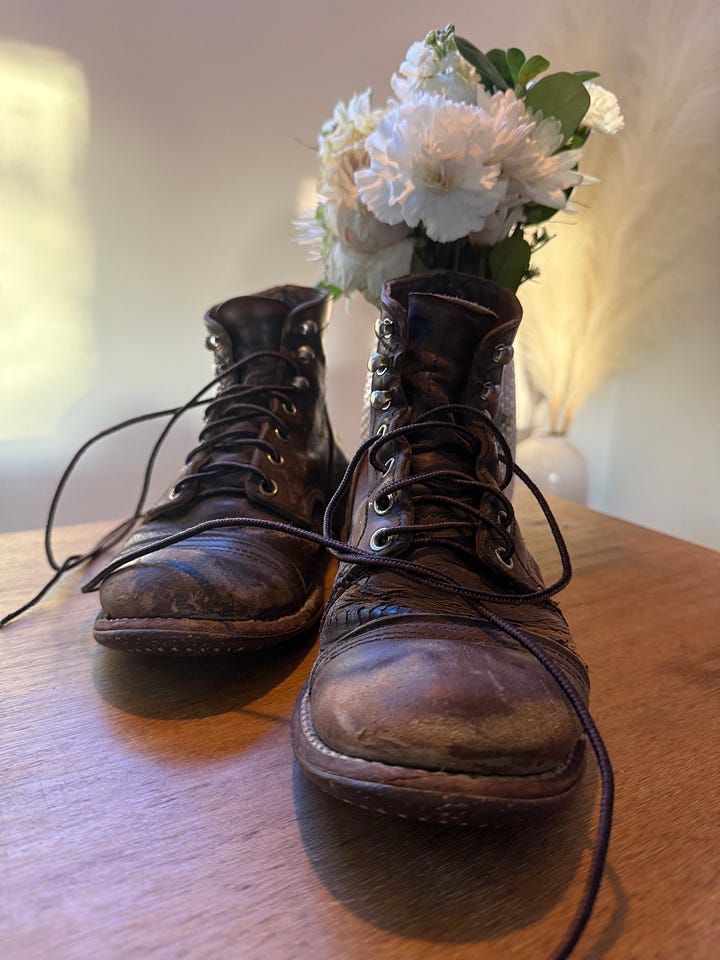 Andrea's boots on meg's bedside table, holding flowers like a vase