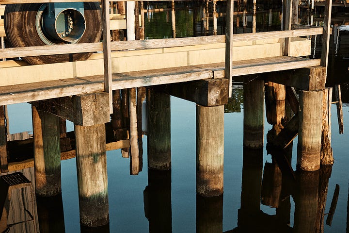 Yellow and blue-green color palette of water and a painted boat lift