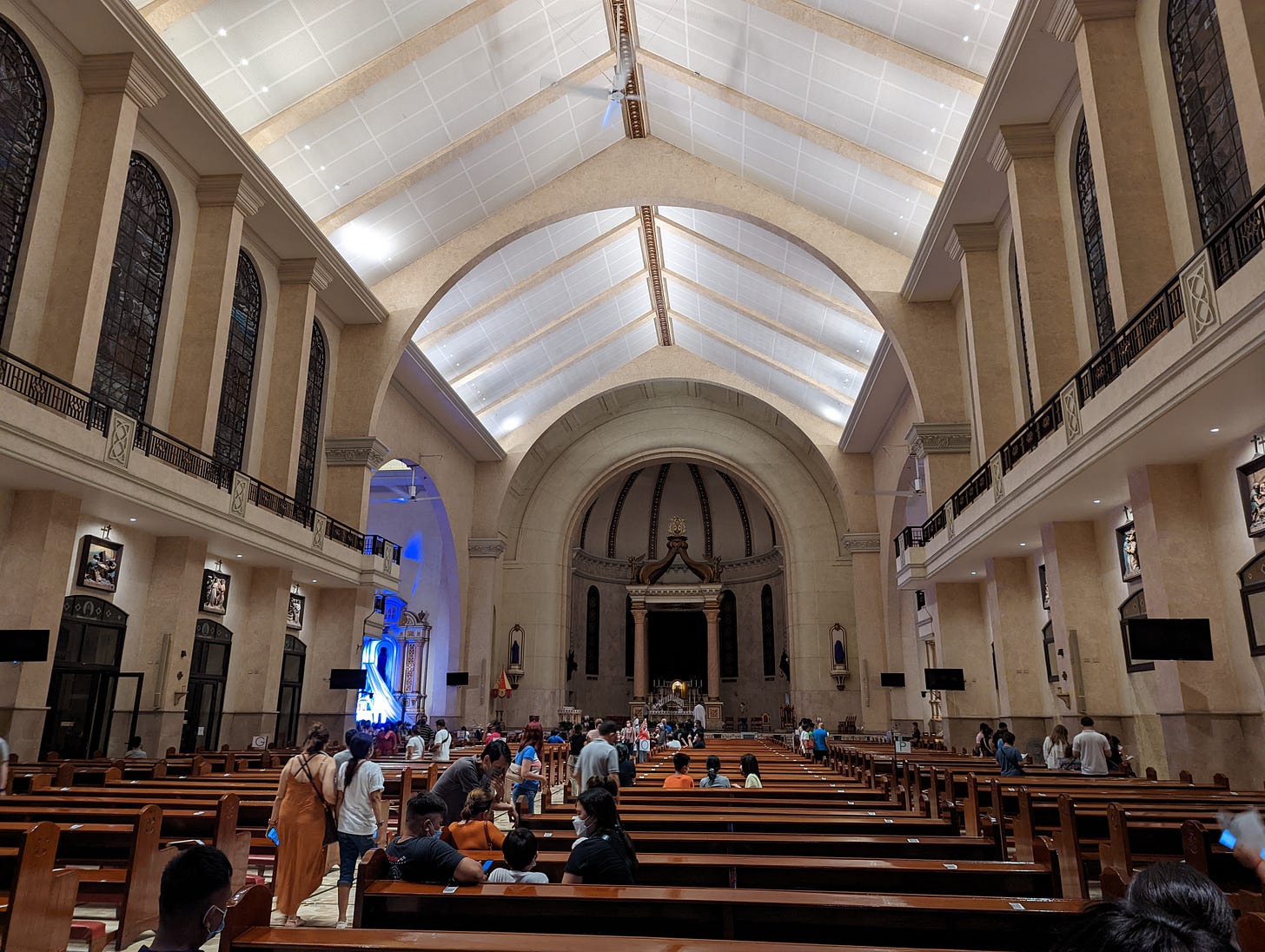 The brightly-lit interior of Our Lady of Mount Carmel with the altar of repose in blue lighting partially visible