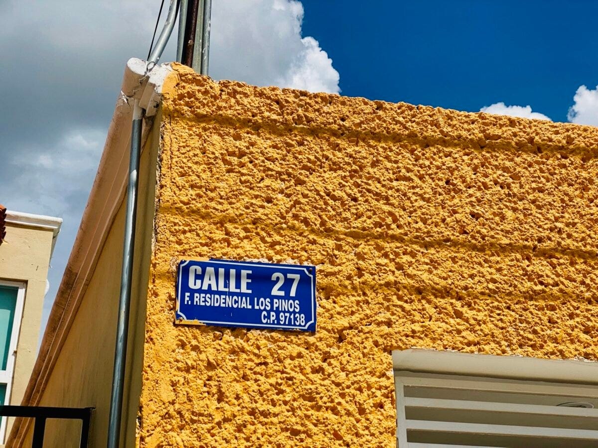 Blue street sign on a yellow house on a corner in a neighborhood in Merida Mexico Blue street sign on a yellow house on a corner in a neighborhood in Merida Mexico