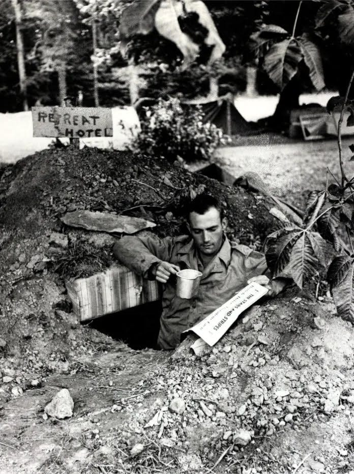 4 de julho de 1944. Um soldado americano lê o jornal das forças dos EUA, The Stars and Stripes, em sua trincheira na frente da Normandia, na França 4 de julho de 1944. Um soldado americano lê o jornal das forças dos EUA, The Stars and Stripes, em sua trincheira na frente da Normandia, na França
