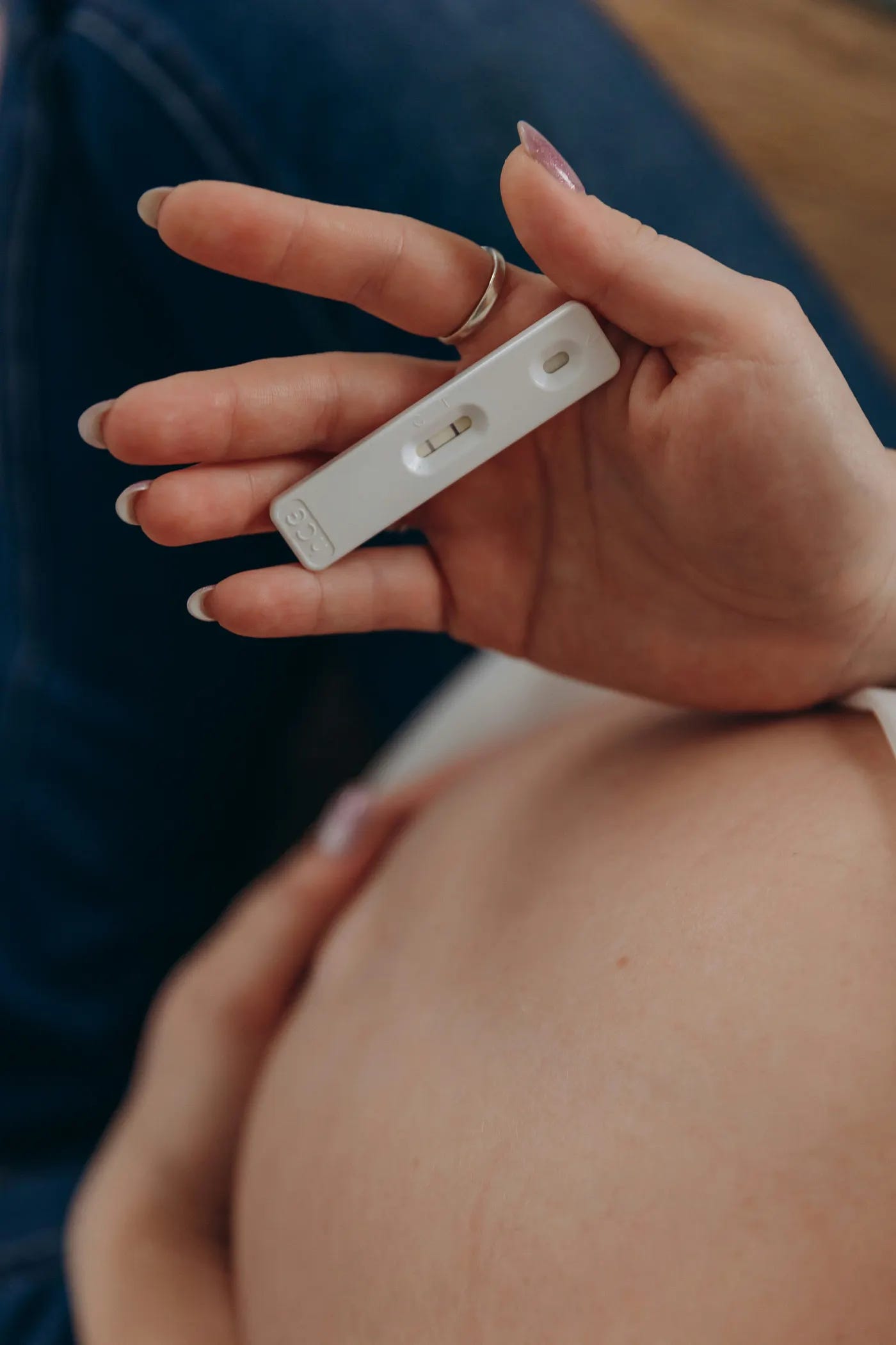 A woman holding a positive pregnancy test in her hands A woman holding a positive pregnancy test in her hands