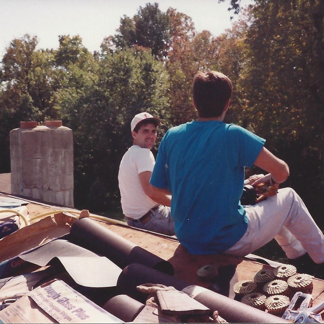 Two young men sitting on a roof getting ready to put new shingles on Two young men sitting on a roof getting ready to put new shingles on