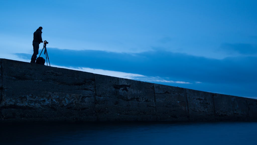 Photo of Phil Newberry with camera and tripod at Dunseverin Harbour shooting a seascape during blue hour