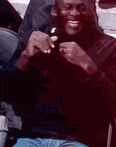 a man is sitting in a chair and smiling while holding a piece of food .