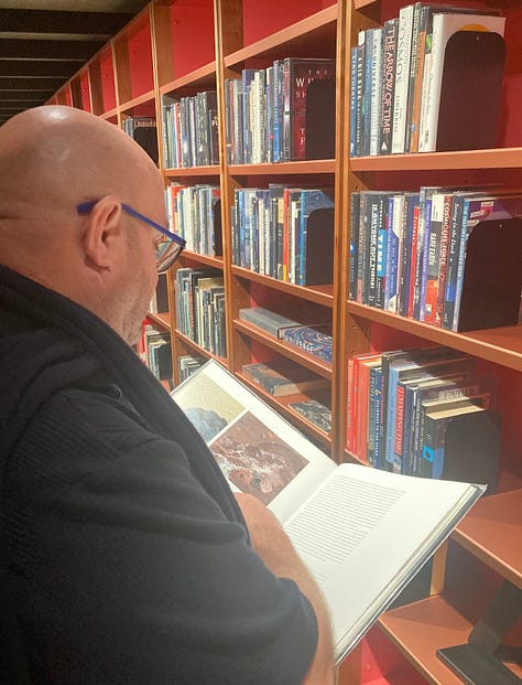 A series of nine photos inside the new library at MONA art museum shows shelves of books, reading lounges, cheeky covers, artist books, globes and more.