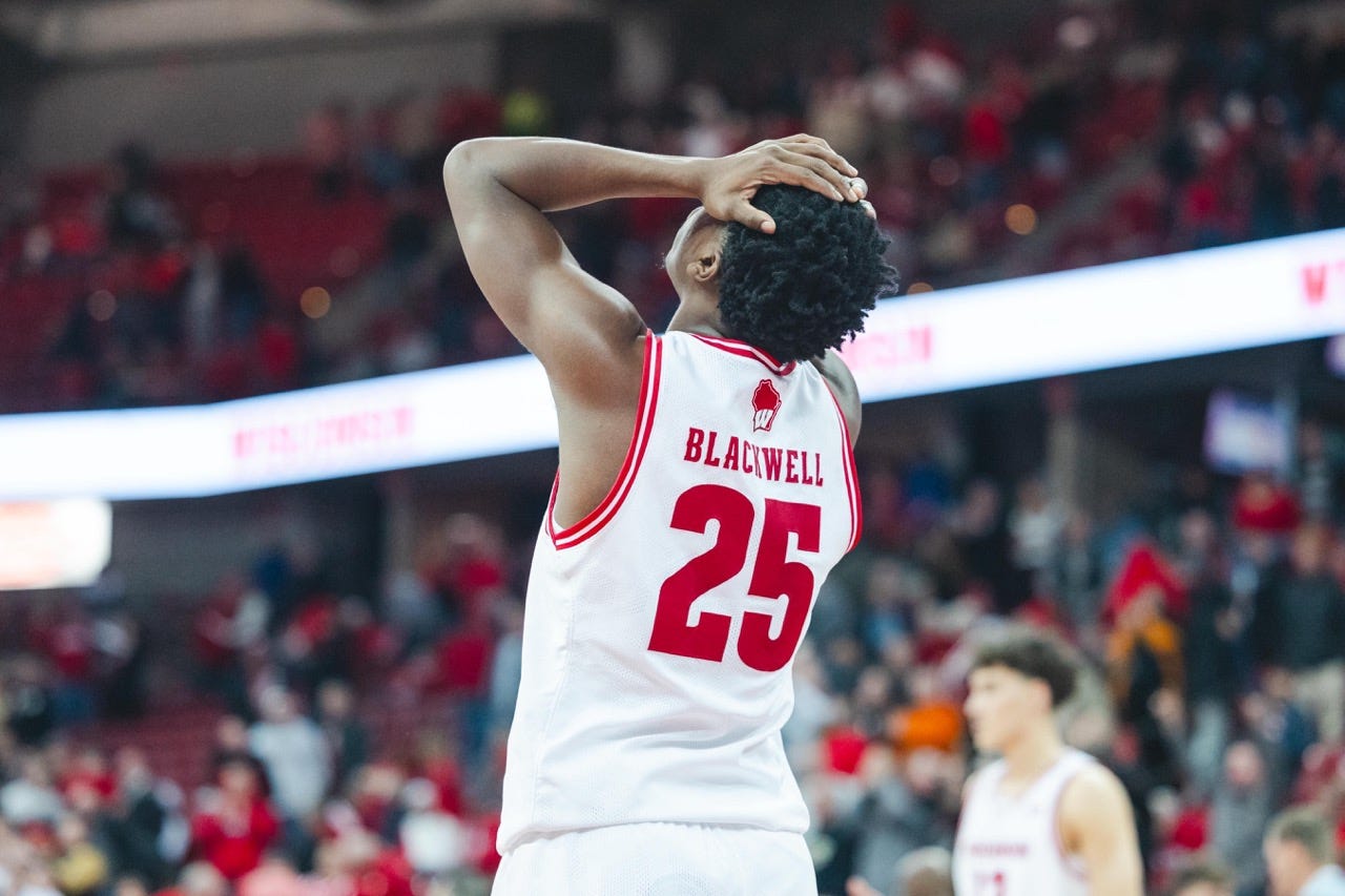 Blackwell, facing away from the camera, puts both hands to his head