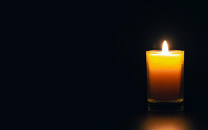 A single lit candle in the dark. A single lit candle in the dark.