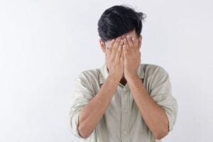 man covering his face in shame man covering his face in shame