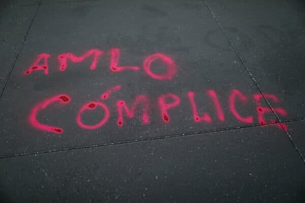 Graffiti saying “AMLO is complicit,” referring to President Andres Manual López Obrador of Mexico, outside the National Palace in Mexico City. He and his party have been criticized for supporting a candidate accused of rape.