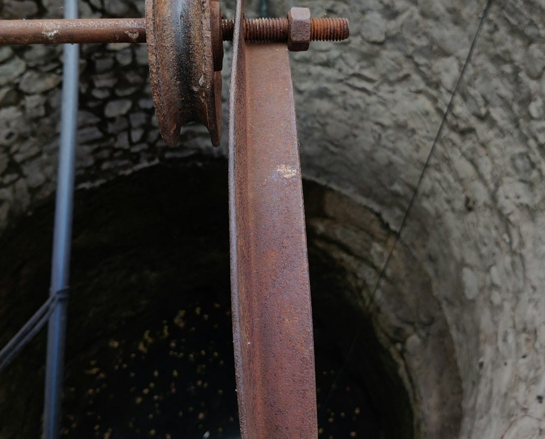 a rusty pipe with a rusted handle in a well