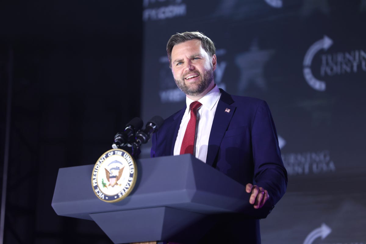 JD Vance giving a speech while standing at a lecturn that displays the vice presidential seal
