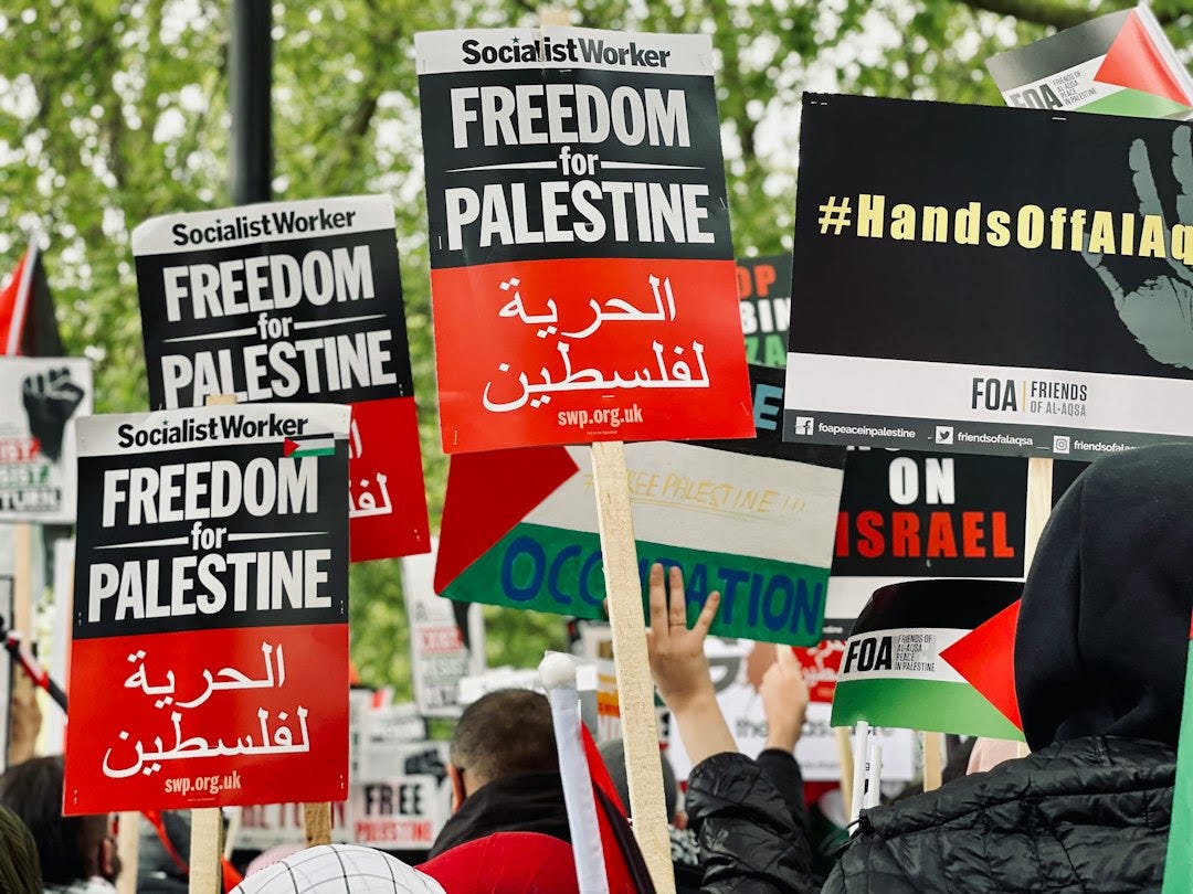 people holding red and white banner during daytime people holding red and white banner during daytime