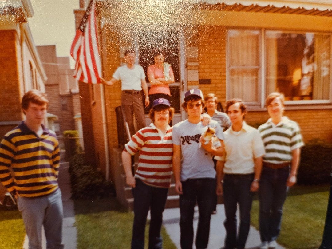A group of young men standing outside a brick house in the 1970s, one wearing a Villanova sweatshirt A group of young men standing outside a brick house in the 1970s, one wearing a Villanova sweatshirt