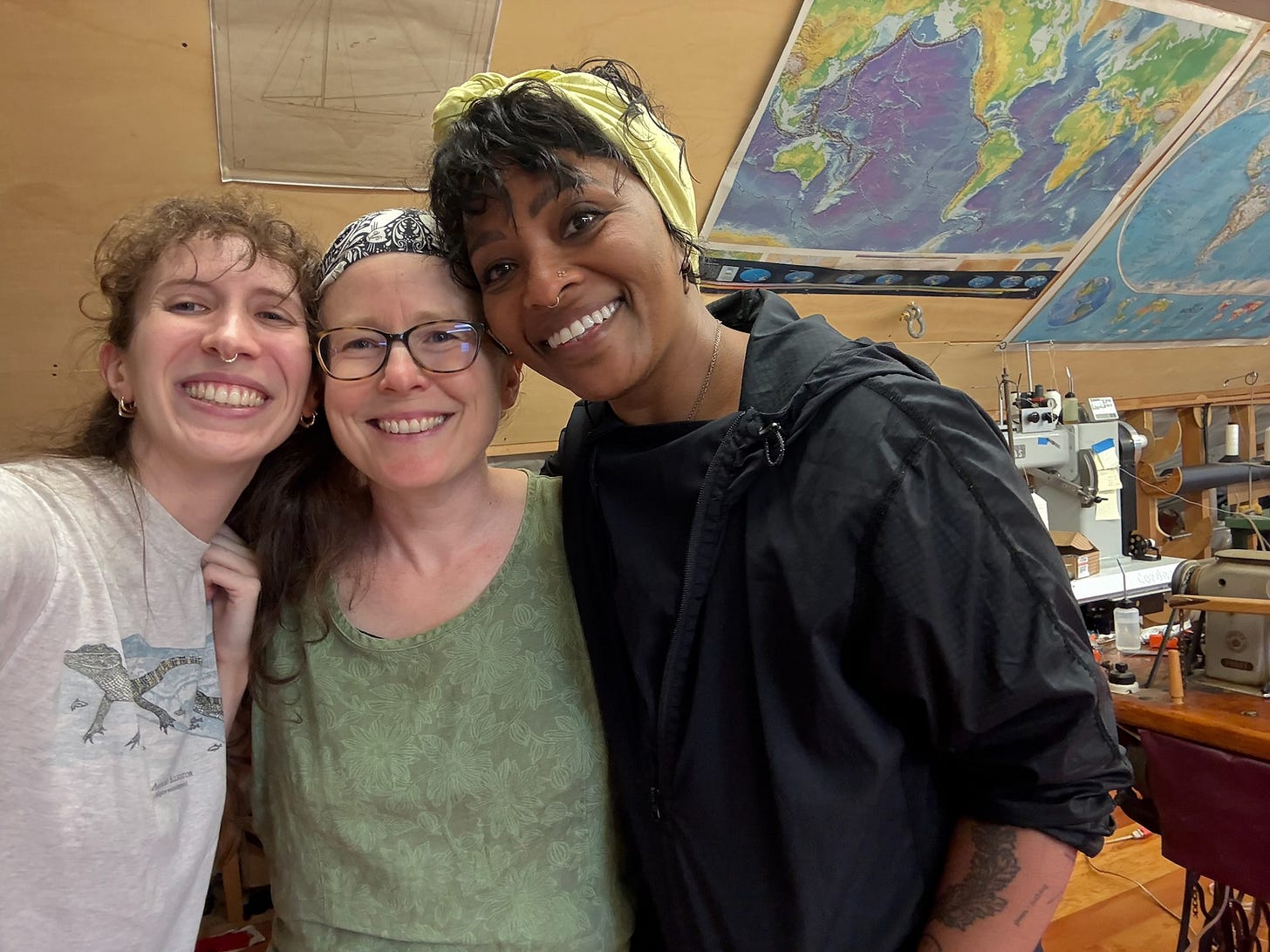 Three smiling artists on top floor of an open workshop. Their heads are pressed together. Three smiling artists on top floor of an open workshop. Their heads are pressed together.
