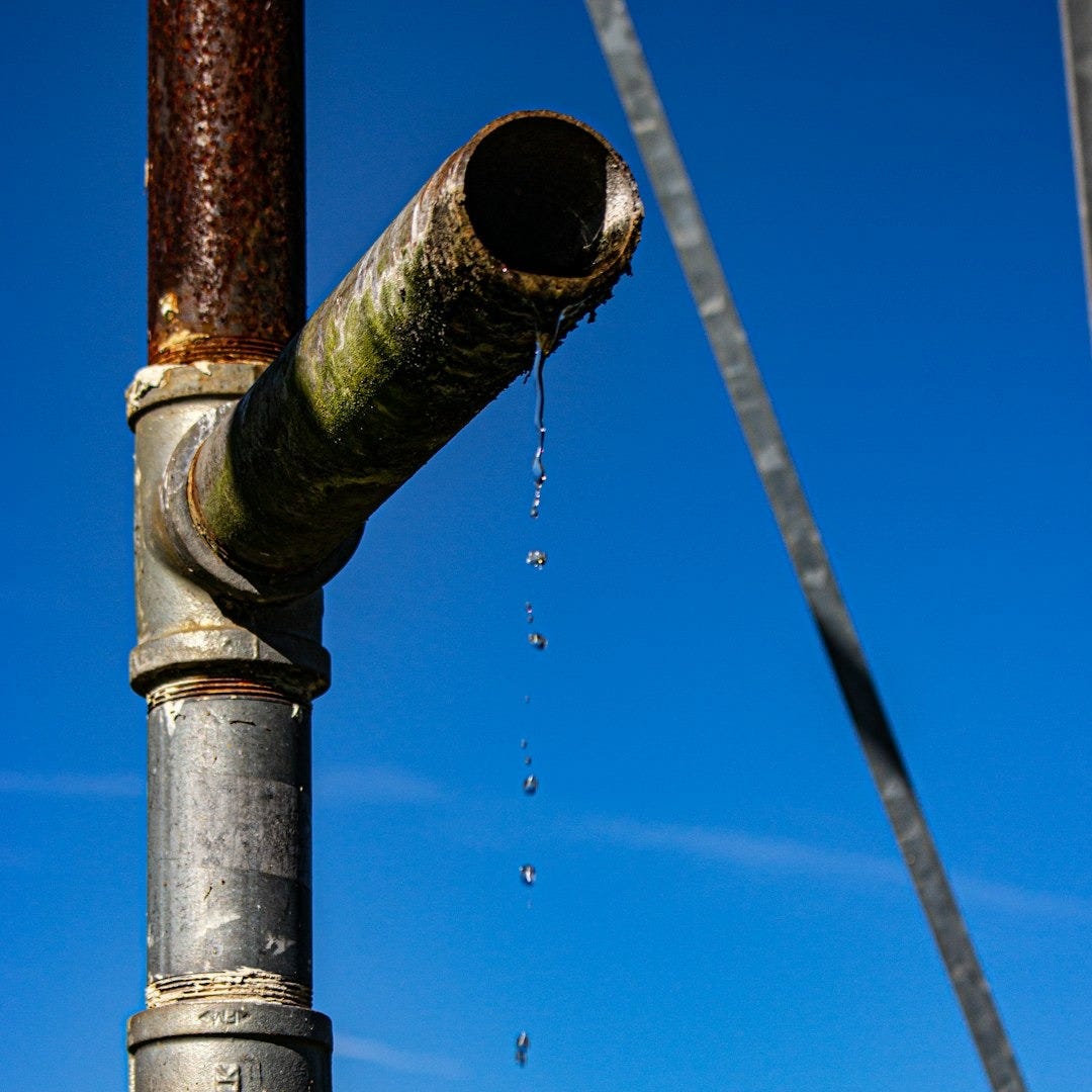 a metal pipe with water coming out of it