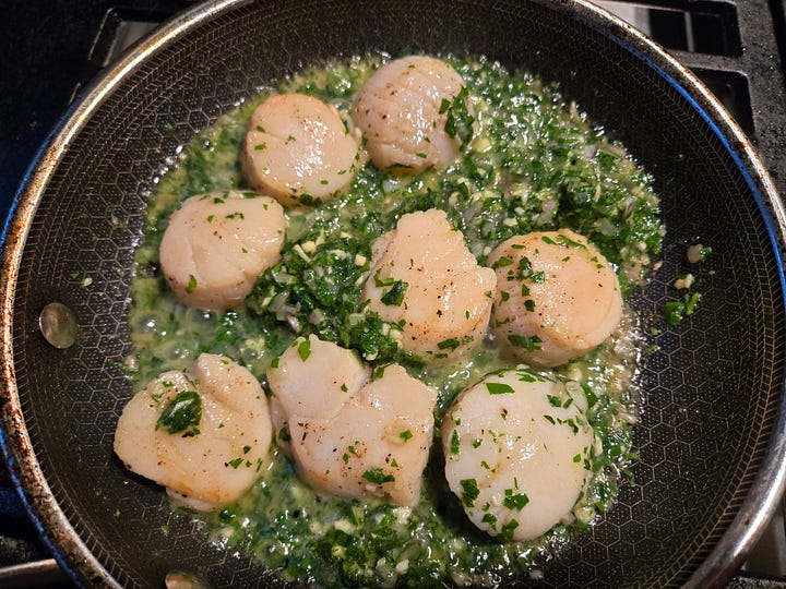 Left: a bowl with compound butter showing finely diced shallot and garlic and chopped parsley throughout. Right: a skillet with cooked scallops, and melting compound butter all around.