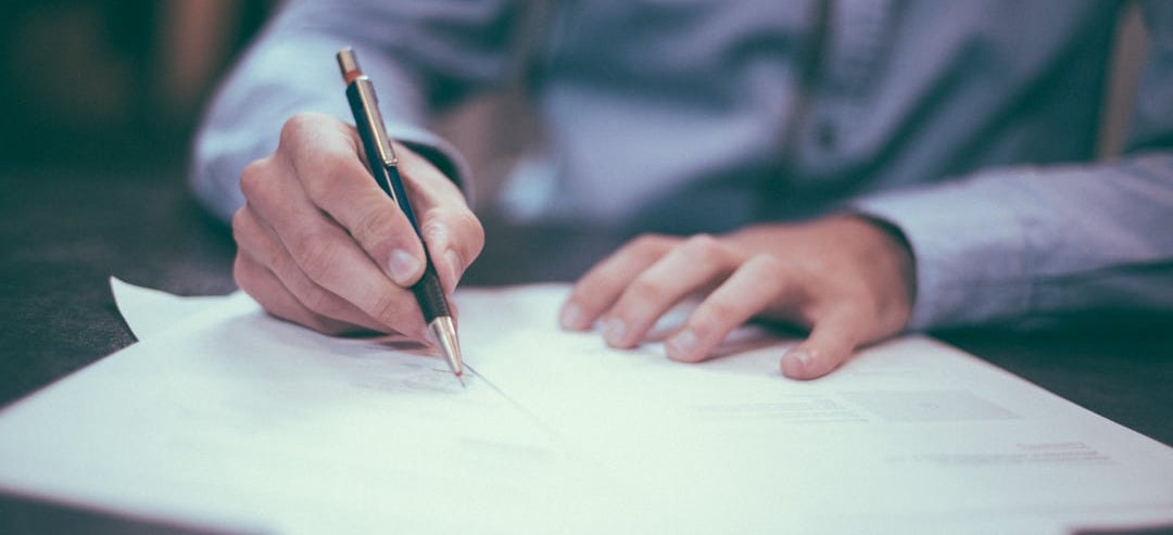 man writing on paper