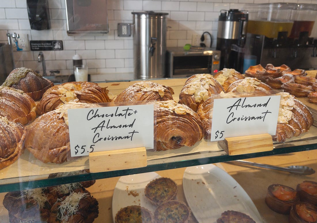 A pastry case containing chocolate almond croissants and almond croissants