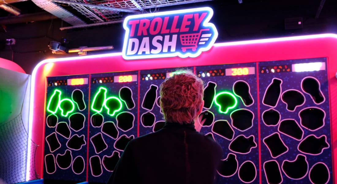 A pink and green screen that says trolley dash with neon lights around it A pink and green screen that says trolley dash with neon lights around it