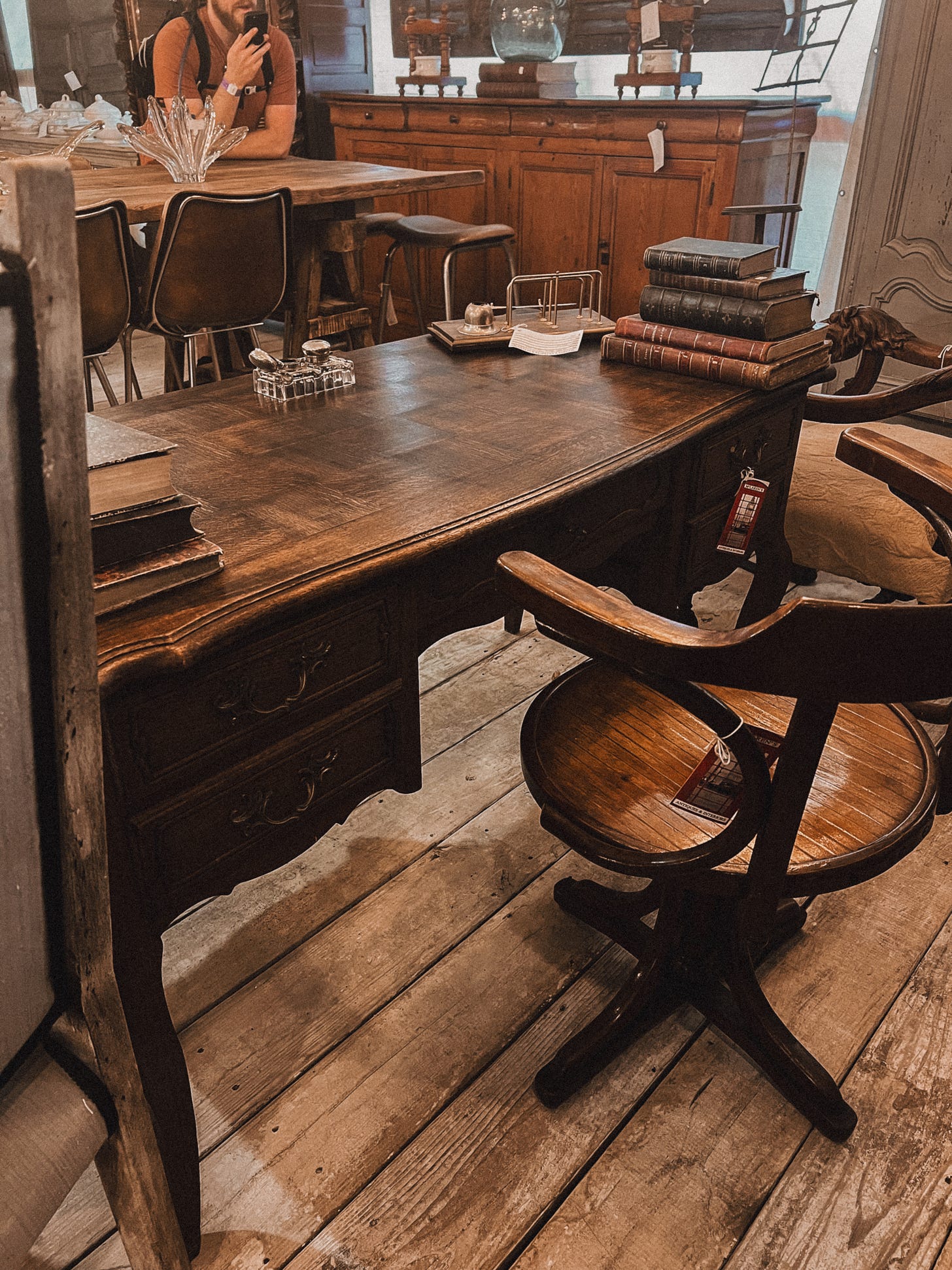 A beautiful Louis XV-style desk sitting in the middle of an elegantly cluttered antique shop.