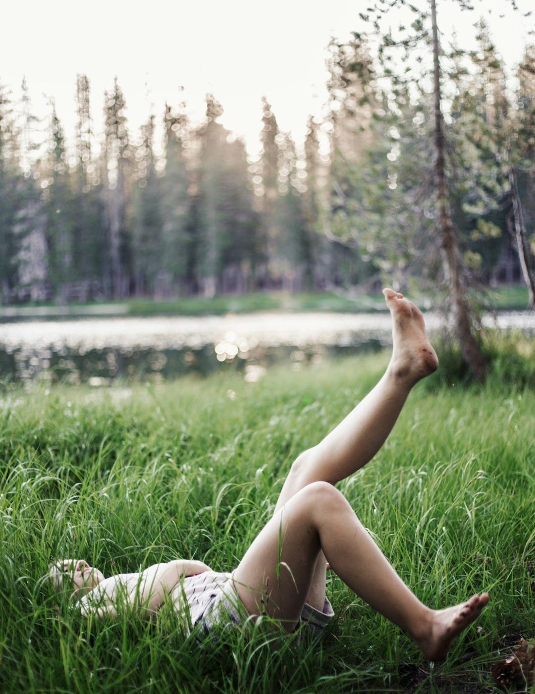 girl laying on green grass field girl laying on green grass field