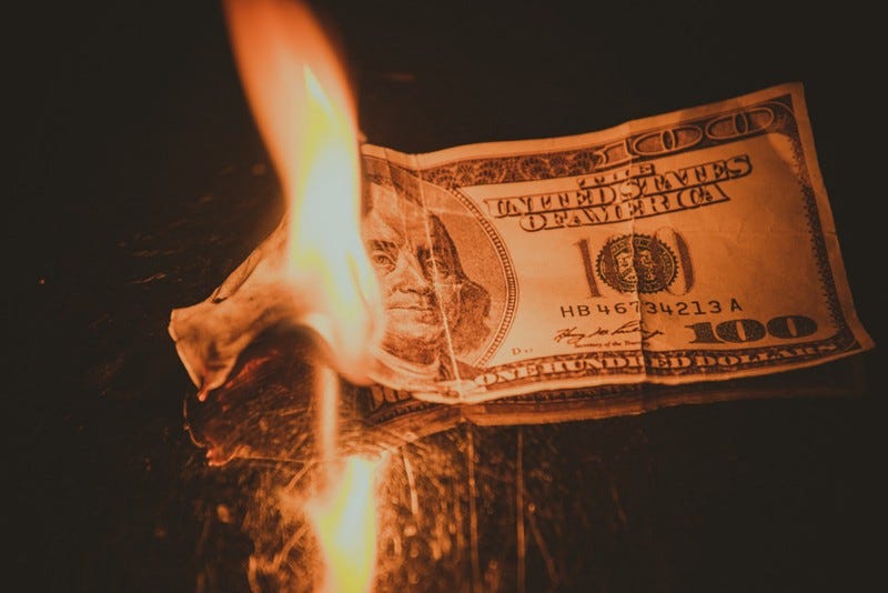 $100 USD on fire $100 USD on fire