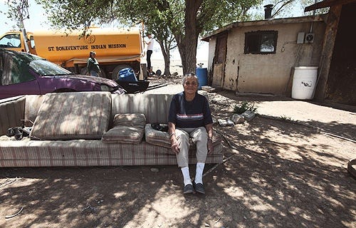 A Navajo elder sits in her yard while water is delivered to her home in Smith Lake, NM. Credit: DigDeepWater.org.