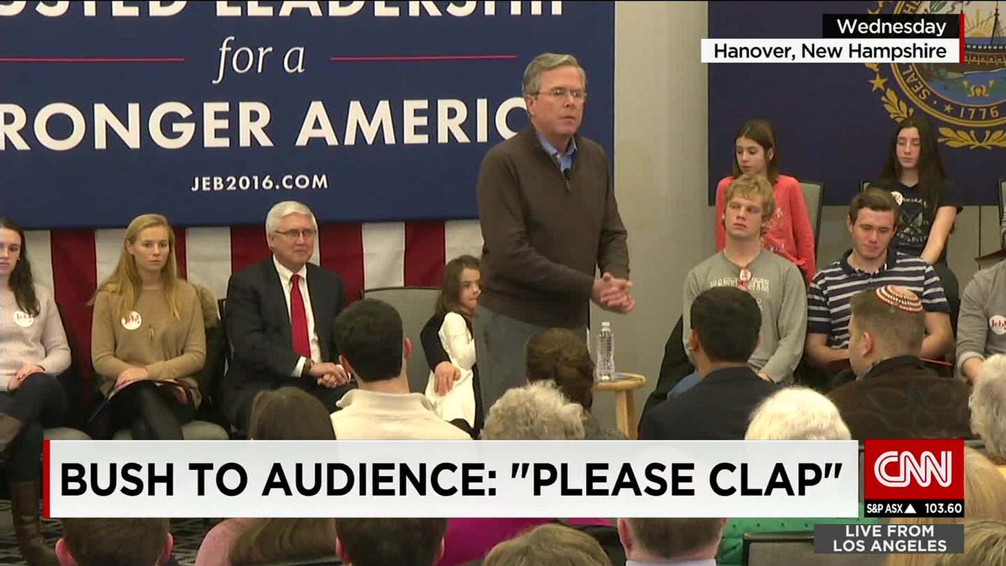 A CNN news screencap depicting Jeb Bush at a press conference with the caption "Bush to audience: 'Please clap'" A CNN news screencap depicting Jeb Bush at a press conference with the caption "Bush to audience: 'Please clap'"