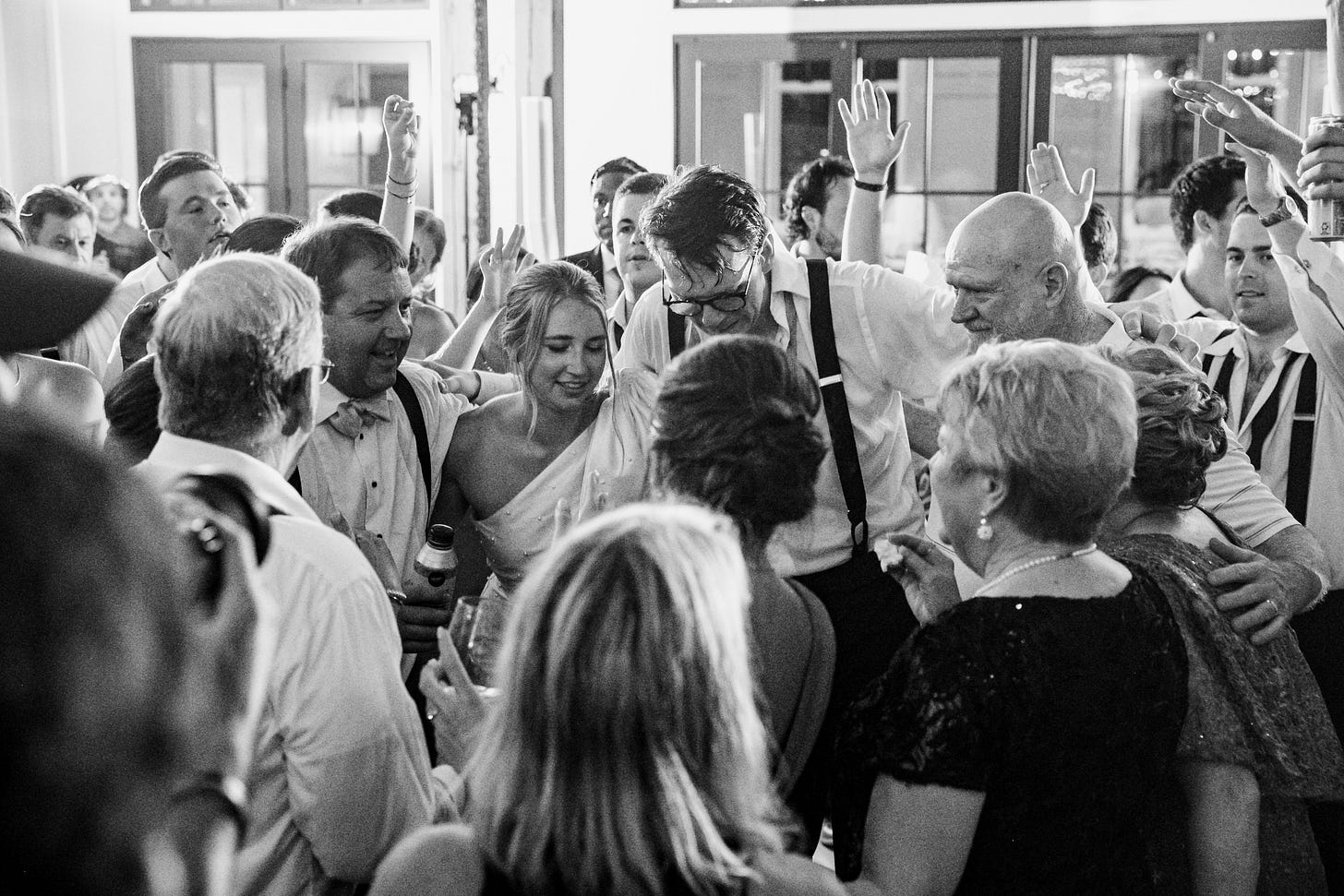 a group of people on the dance floor at a wedding