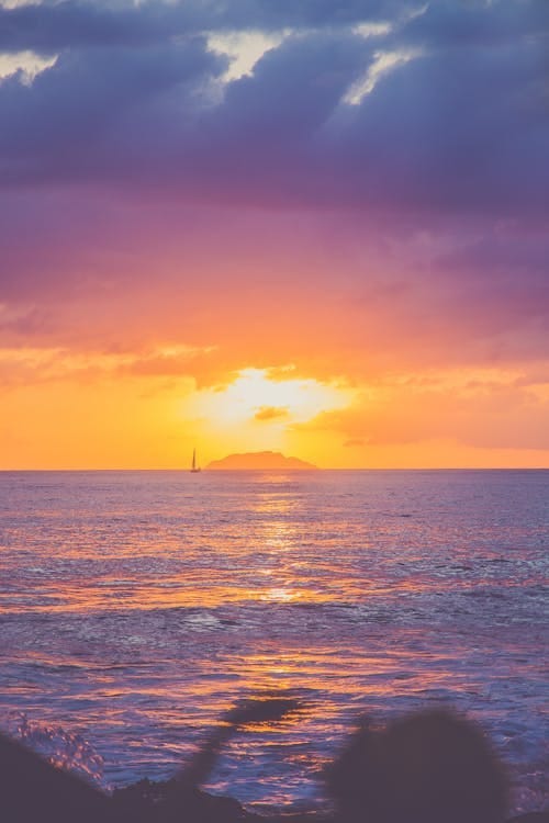 Free Stunning sunset over the ocean in Puerto Rico with dramatic clouds and serene waters. Stock Photo Free Stunning sunset over the ocean in Puerto Rico with dramatic clouds and serene waters. Stock Photo