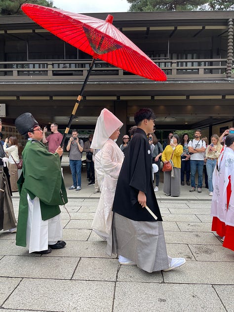 A collage of nine photos from Japan: a man in traditional kimono performing a tea ceremony; a tray of delicate kaiseki dishes with seasonal ingredients; a serene temple garden surrounded by moss and trees; a tatami room with sliding shoji doors; a mountain view with Mount Fuji in the distance; a bowl of Japanese dessert with green grapes and jelly; a Shinto wedding procession under a red umbrella; a moss-covered stone Buddha statue in a forest; and misty temple grounds framed by lush greenery.