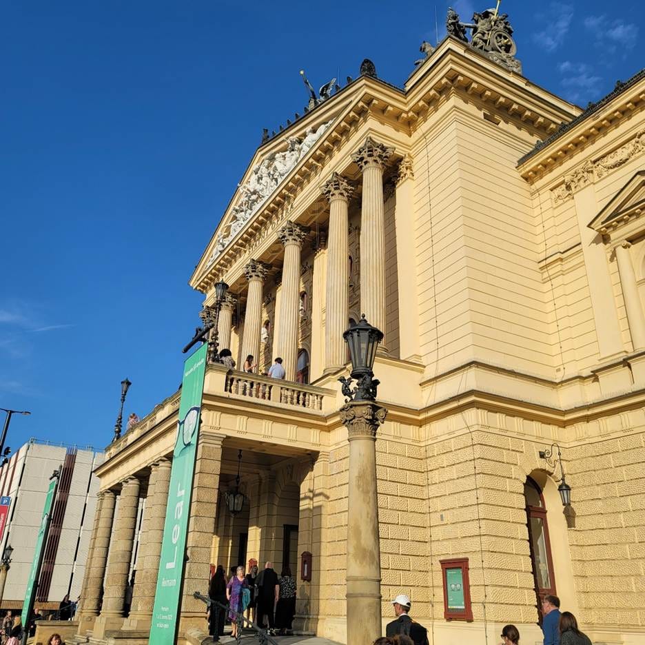 A building with columns and people standing outside

AI-generated content may be incorrect.