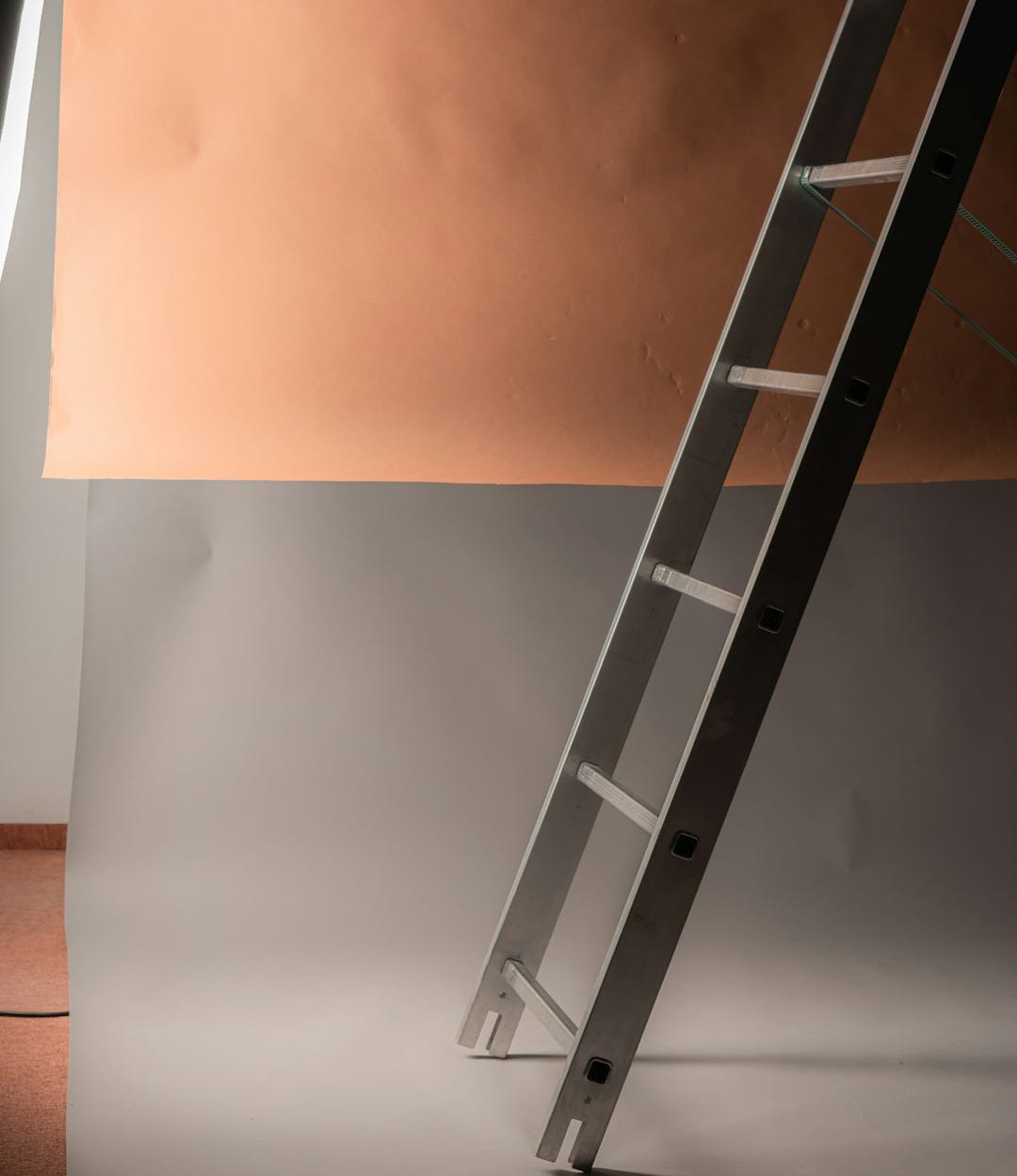 a ladder leaning against a wall in a room a ladder leaning against a wall in a room