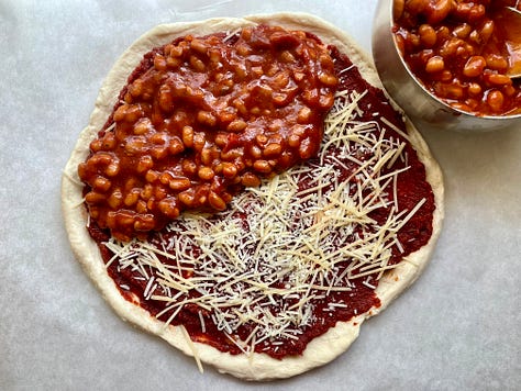 Pressed biscuit crust layered with enough tomato paste to kill a small bison, parmesan, baked beans, and a pile of mozzarella and green pepper slices right in the middle where they can't do anyone any good
