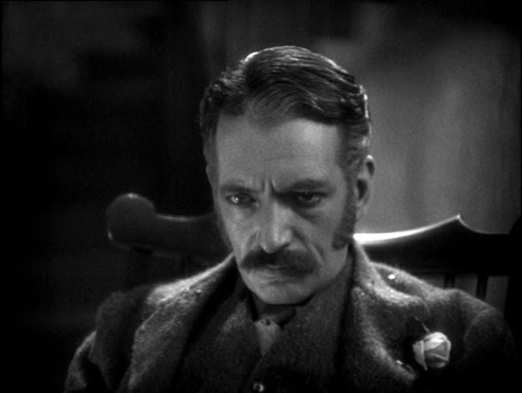 A person with a mustache sitting in a chair

Description automatically generated